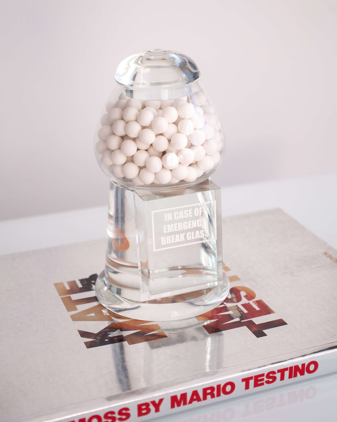 A clear crystal gumball sculpture filled with white gumballs