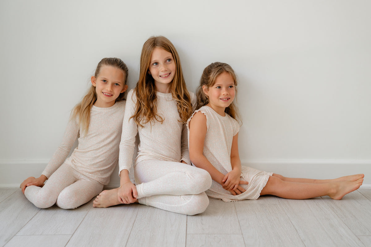 Three girls in Blooming Toile pajamas against a white wall